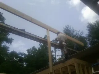 Carpenter setting a ridge beam over a new addition frame — Ice Dam Removal by Roofing Brothers in Franksville