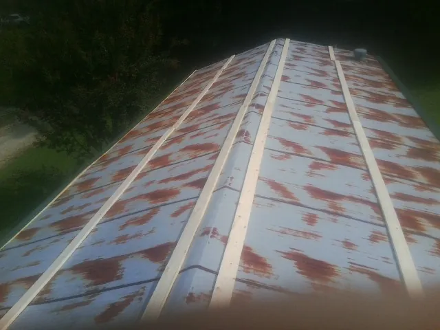 Rusted metal roof panels with new wood purlins before replacement — Storm Damage Roof Repair in Franksville by Roofing Brothers
