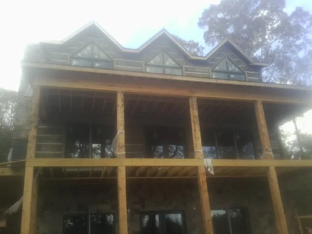 Dormers and porch framing on a large log home under construction — Roof Coating work by our crew in Franksville