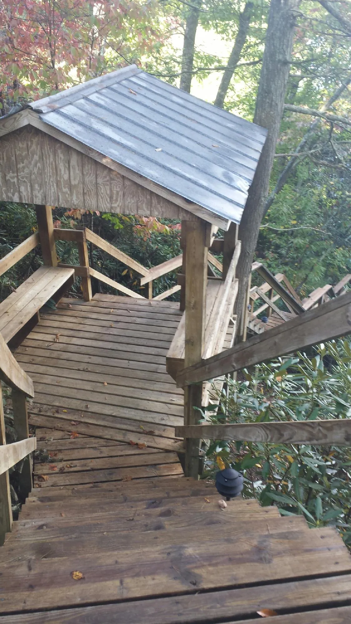 Metal roofed shelter over wooden steps on a wooded walkway — Skylight Repair & Installation work by our crew in Franksville