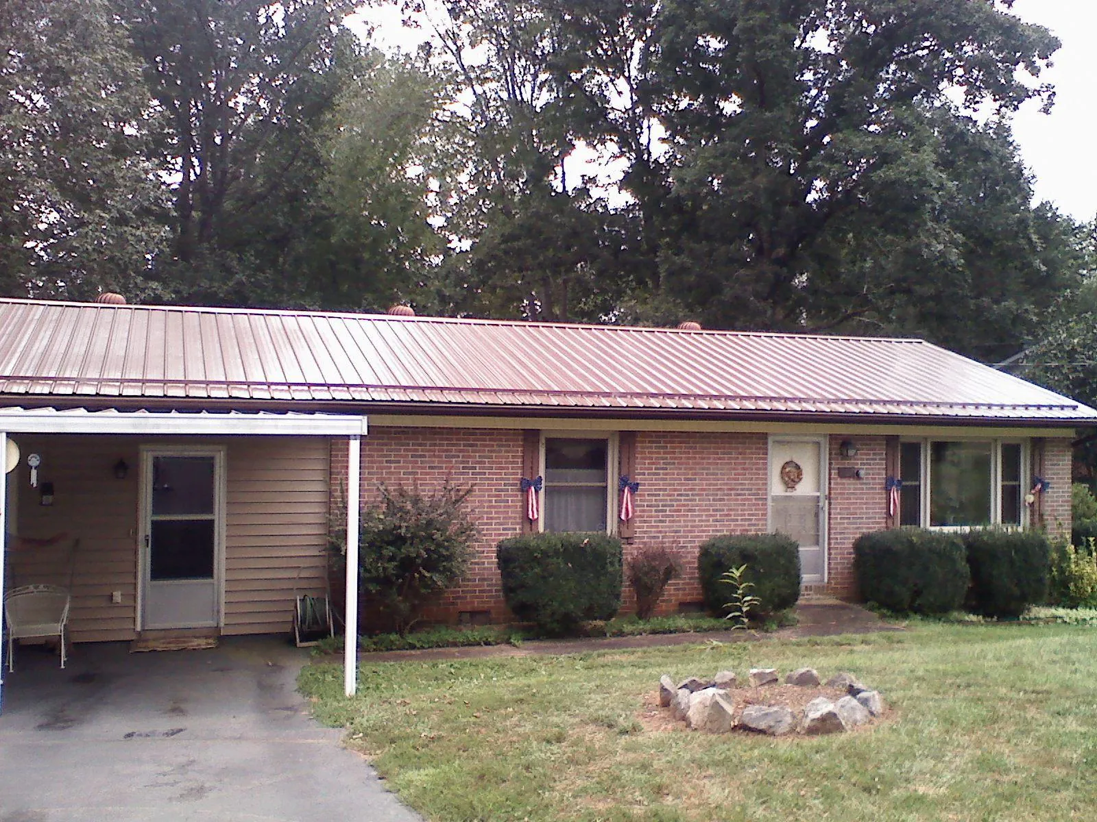 Bronze metal roof and carport on a brick ranch home — Roof Repair work by our crew in Franksville