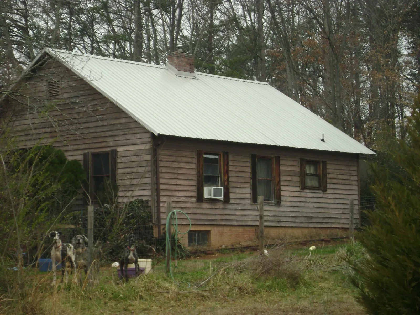 White metal roof on an old wood sided farmhouse, from a Metal Roof Installation job in Franksville